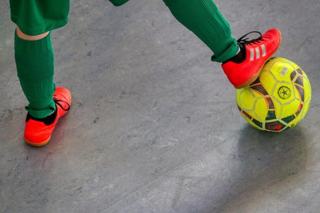 Spelers spelen zaalvoetbal in Den Haag in een sportzaal met snelle en behendig voetbal