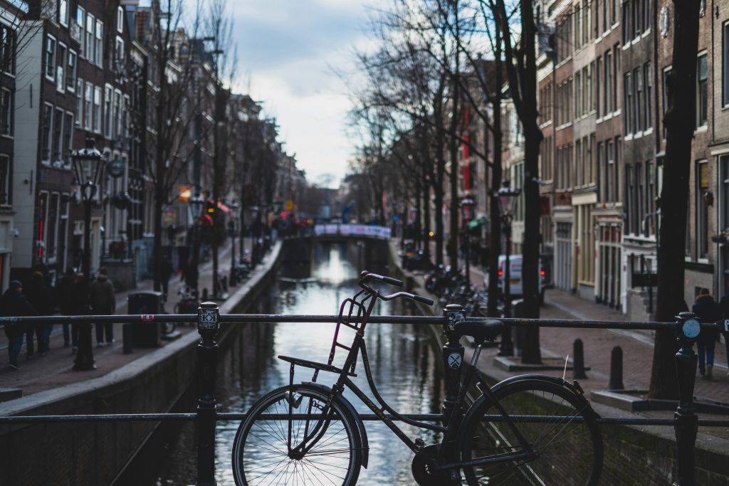 Grachtenhuizen en fietsers in Amsterdam, de perfecte plek om te wonen met geschiedenis en moderne voorzieningen