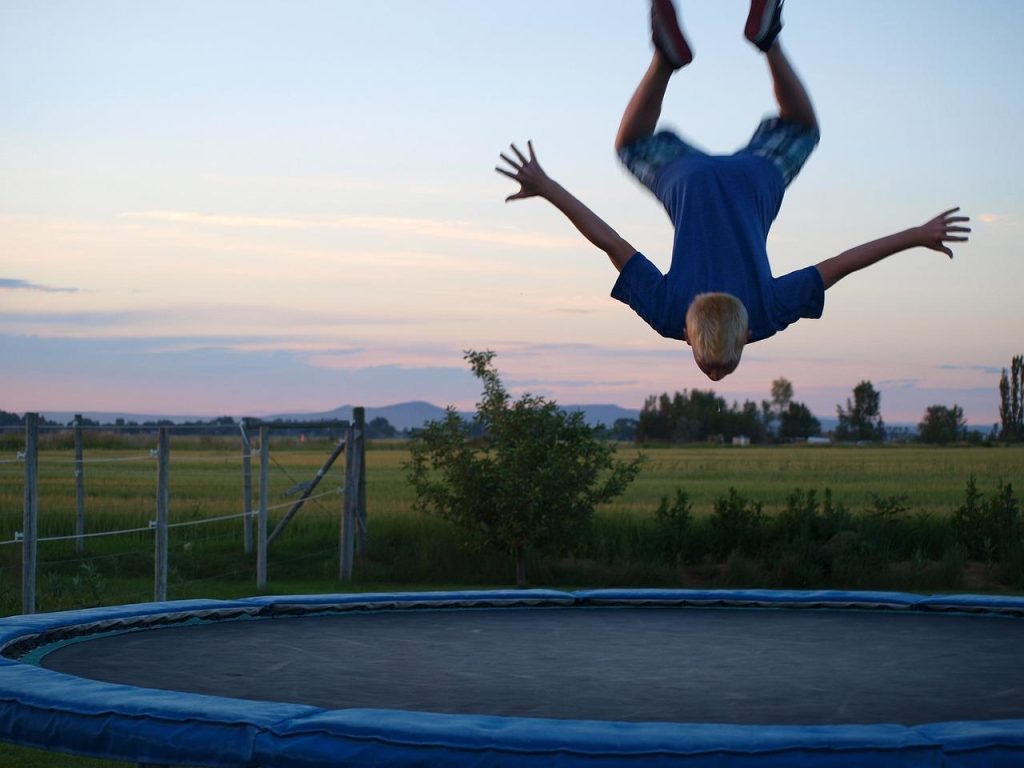 Familie springt op trampoline in de tuin, demonstreert voordelen en plezier van trampolines