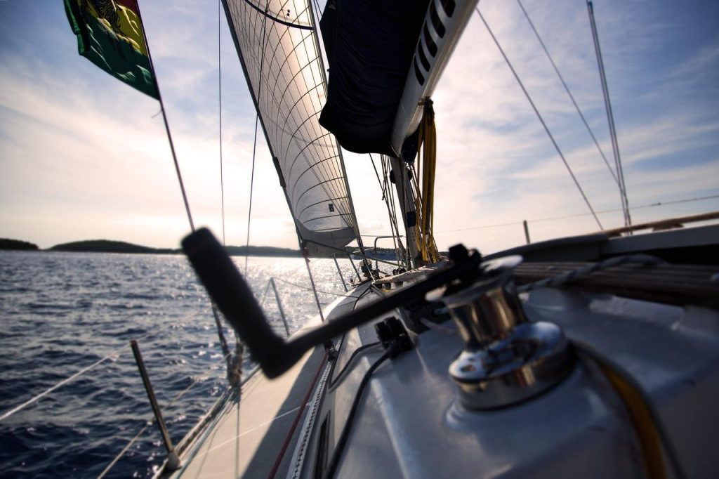Zeiler geniet van wind en zeilen op kristalhelder water, perfect voor het ontdekken van de magie van zeilen