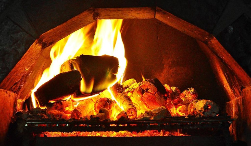 Houtkachel met knisperend vuur in woonkamer, biedende authentieke warmte en gezellige sfeer in huis