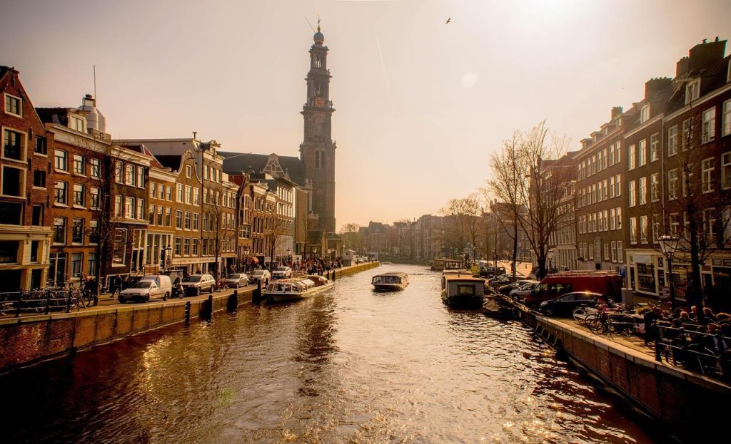 Serene grachtenrondvaart in Amsterdam met statige panden en reflecties in het water voor een authentieke stadsbeleving