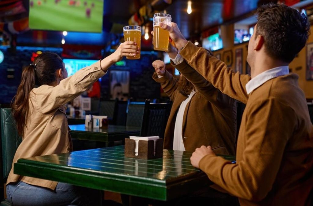 Groep vrienden speelt pubquiz in Amsterdam cafe, beantwoordt vragen en lacht samen